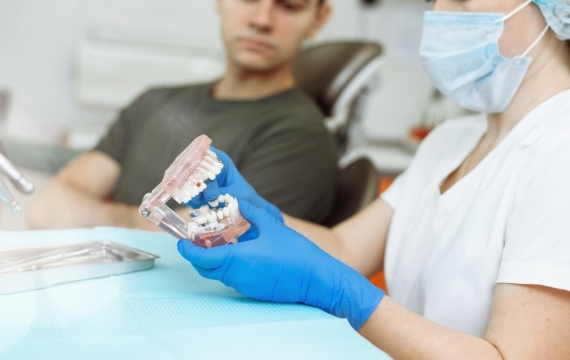 dentista-explicando-con-dientes-artificiales-al-paciente-catarroja dentista-explicando-con-dientes-artificiales-al-paciente